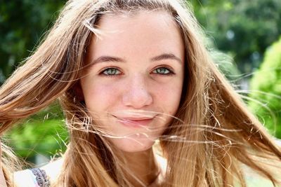 Close-up portrait of smiling teenage girl outdoors