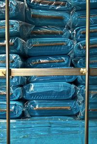 Close-up of fabric stacks arranged at shop seen through fence