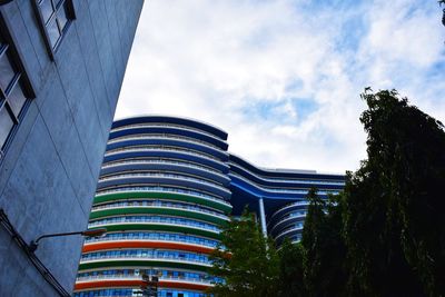 Low angle view of buildings against cloudy sky