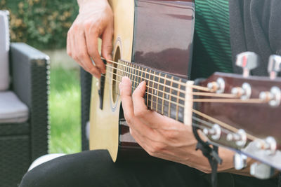 Midsection of man playing guitar