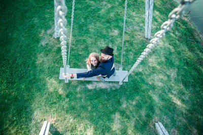 High angle view of man sitting on swing at playground