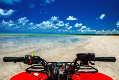 Quadbike at beach against sky