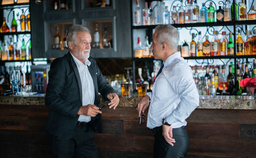 Full length of a man standing in front of bar