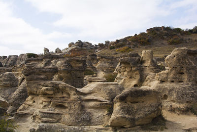 Low angle view of rock formation against sky