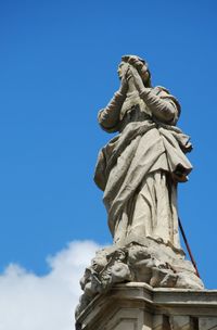 Low angle view of statue against blue sky