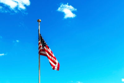 Low angle view of flag against blue sky