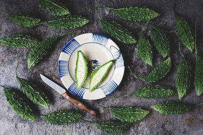 Directly above shot of bitter gourds with slices on table