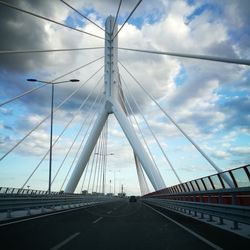 View of suspension bridge against cloudy sky