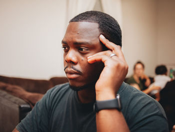 Close-up of man looking away while sitting at home