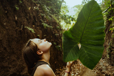 Low section of teenager girl holding leave