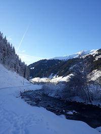 Scenic view of snowcapped mountains against clear blue sky