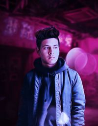 Portrait of young man standing against wall