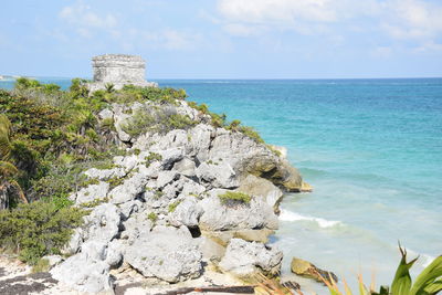 Scenic view of rocks on beach against sky