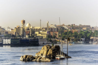 Egypt, aswan governorate, aswan, islet in nile river with city buildings in background