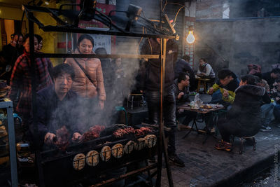 People on barbecue grill at market