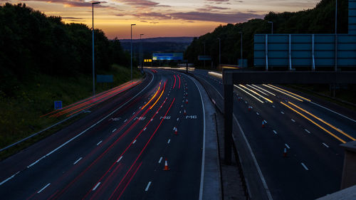 Light trails on road against sky at night