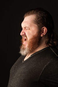 Portrait of man against black background