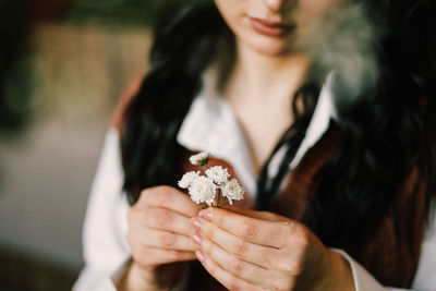 Midsection of woman holding flower bouquet