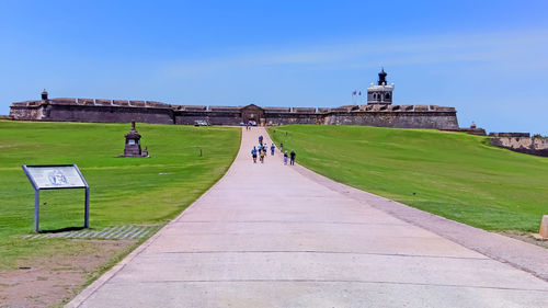 People on walkway against clear sky