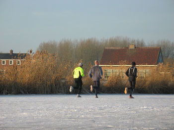 People on snow against clear sky