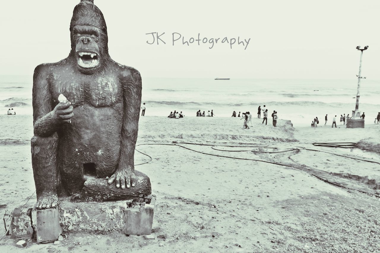 sea, beach, water, horizon over water, shore, clear sky, sand, human representation, sculpture, art, art and craft, day, creativity, sky, outdoors, nature, statue, copy space, tranquility, bird