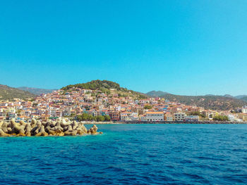 Panoramic view of sea and buildings against clear blue sky