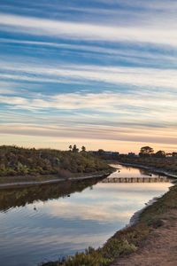 Bridge over river against sky during sunset