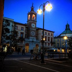 Illuminated street light against sky at night