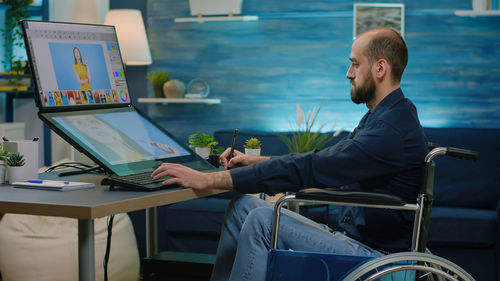 Midsection of man using laptop at office