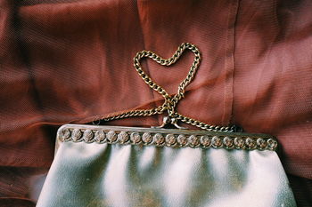 Close-up of heart shape made from purse on brown fabric
