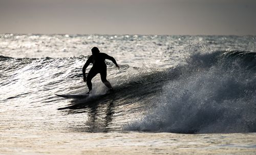 Man surfing in the sea against clear sky