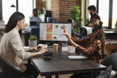 Girl wearing virtual reality simulator at office