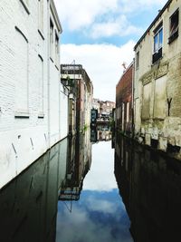 Canal amidst buildings against sky