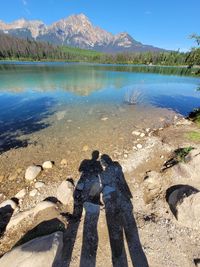 Shadow of man and woman standing on lake