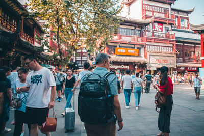 People walking on street against buildings in city