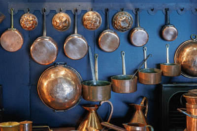 Copper pots and pans and other kitchen utensils in an antique metal kitchen.