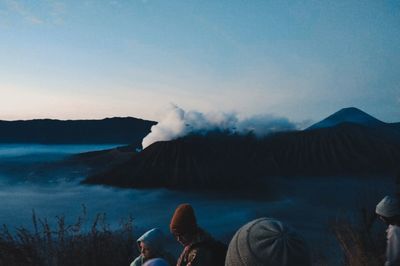 People enjoying in lake against sky