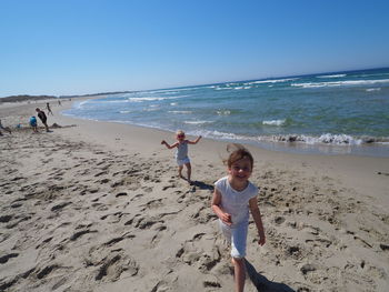 Full length of girl on beach against sky