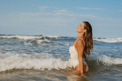 Portrait of young woman standing at beach