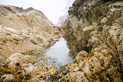 Water reflection in puddle at rocky coast