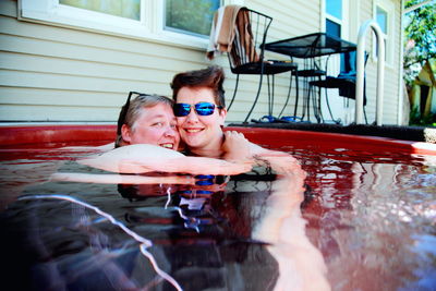 Portrait of lesbian couple embracing in pool