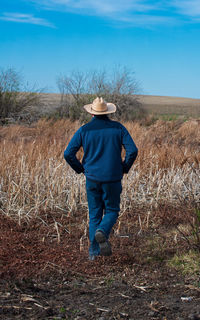 Rear view of man walking on field