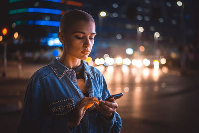 Young man using mobile phone at night