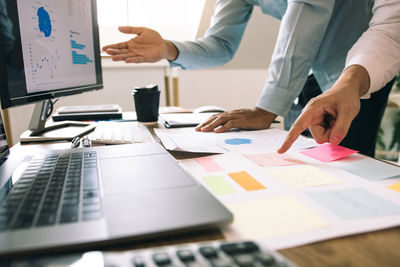 Midsection of business people working on table