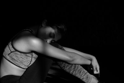 Tired woman sitting in darkroom