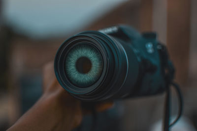 Cropped hand of man holding camera