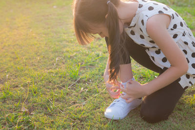 Side view of young woman on field