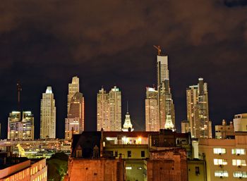 Modern buildings in city against sky at night