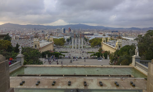 High angle view of city buildings against cloudy sky