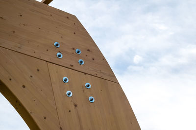 Detail of a modern wooden architecture in glued laminated timber on a blue cloudy sky